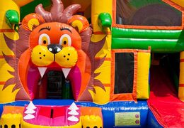 Springkussen in leeuw thema met glijbaan, pilaren op het springvlak en opvallende 3D objecten bestellen voor kinderen.  Koop opblaasbare springkussens online bij JB Inflatables Nederland