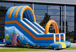 Oceanworld slide glijbaan met de vrolijke kleuren en leuke print op de achterwand kopen. Bestel opblaasbare glijbanen nu online bij JB Inflatables Nederland