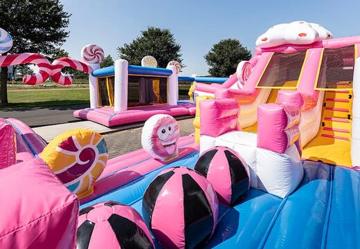 World Candyland springkussen met meerdere glijbanen en allerlei obstakels met prints die passen bij het thema bestellen voor kinderen. Koop springkussens online bij JB Inflatables Nederland 