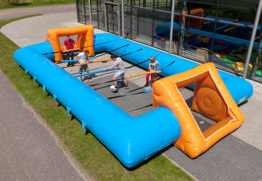 Opblaasbare blauw oranje tafelvoetbal met unieke boardingschuifsysteem voor kids kopen. Bestel opblaasbare tafelvoetbal nu online bij JB Inflatables Nederland